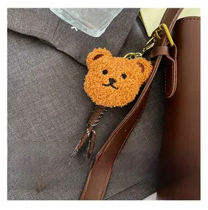 Détail d'un ours en peluche marron avec cordon tressé sur un sac seau en cuir