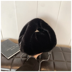 Détail du sac à main en fausse fourrure noire avec bandoulière chaîne argentée et décor moderne