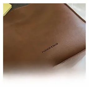 Gros plan détaillé de la texture cuir marron foncé avec lettrage embossé mode et sacs