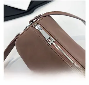 Gros plan de la fermeture éclair argentée et coutures fines du sac bandoulière en cuir
