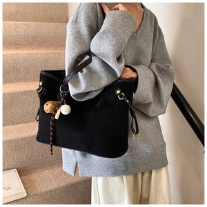 Détail d'un grand sac cabas noir avec texture velours et charms de baseball