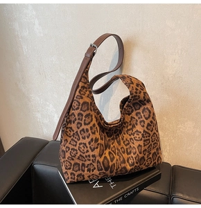 Détail d'un sac cabas léopard avec bandoulière en cuir marron réglable et boucle en métal