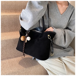 Détail du grand sac cabas en daim noir avec breloques de baseball et boucle en métal