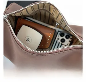 Détail de l'intérieur haute capacité du sac polochon marron avec doublure rayée et zip