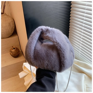 Gros plan du sac à main en fausse fourrure gris-mauve avec une bandoulière argentée