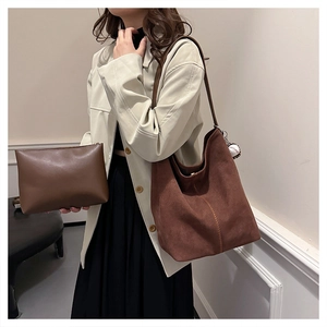 Set aus dunkelbrauner Wildledertasche und passendem Etui am Modell in einem Raum
