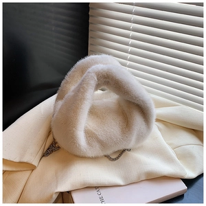 Gros plan d'un sac à main en fausse fourrure blanc cassé avec une élégante chaîne argentée