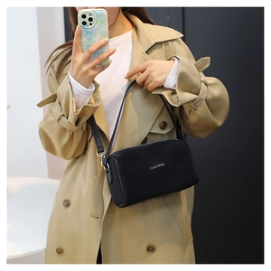 Selfie miroir montrant la taille et l'échelle du sac à bandoulière en cuir noir porté