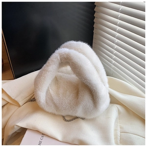 Détail d'un sac à main en fausse fourrure blanche avec une élégante chaîne en métal argenté