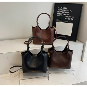 Vue détaillée de sacs seaux de luxe en noir et marron avec bandoulières réglables