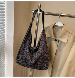 Détail du sac léopard vintage avec bandoulière réglable sur un trench-coat beige chic