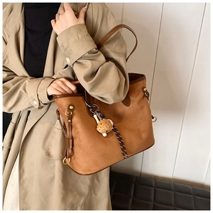 Détail du sac cabas léopard avec texture daim douce et charmant accessoire hérisson