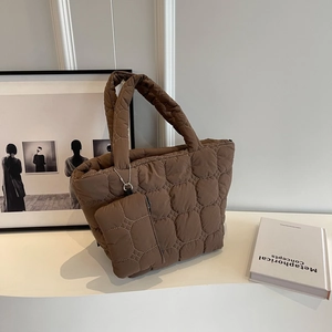 Detailed view of dark brown quilted tote bag with a small matching zipper pouch