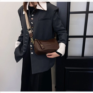 Deep brown crossbody pillow bag with houndstooth strap shown on a gray blazer