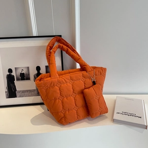 Detail of orange quilted tote bag with matching mini pouch and soft cloud-like texture
