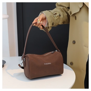 Détail d'un sac polochon vintage marron avec texture mate et poignée de transport
