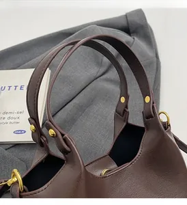 Détail de la poignée en cuir renforcé et ferrures dorées sur sac cabas marron
