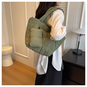 Detailed view of olive green quilted tote bag with matching mini pouch in a soft fabric