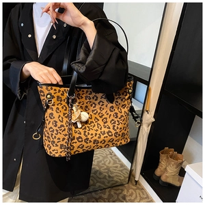 Détail d'un cabas à imprimé léopard avec poignées noires et accessoire foulard décoratif