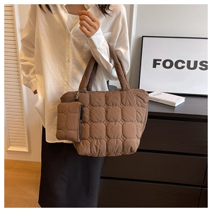 Detail of quilted puffer tote bag in chocolate brown with matching small zip pouch pendant