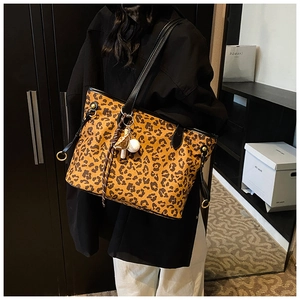Détail d'un grand sac cabas imprimé léopard avec bandoulière noire et ornements