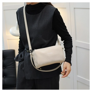 Détail du sac polochon beige en similicuir texturé avec logo GuLiDiLi et bandoulière