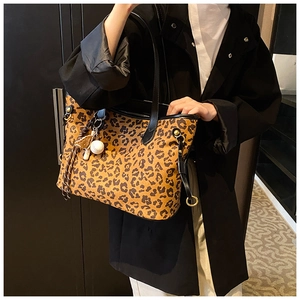 Vue détaillée du sac cabas léopard avec texture en cuir et breloque boule blanche