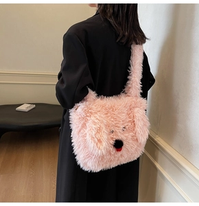 Detail of pink plush dog-shaped tote bag worn over a black coat showing its large size