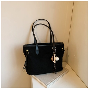 Détail du sac cabas noir avec pendentif de baseball et anneau métallique doré élégant