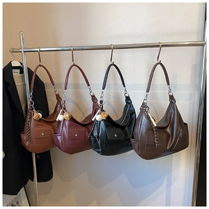 Sélection de sacs hobo rétro en marron, bordeaux et noir sur un présentoir en métal
