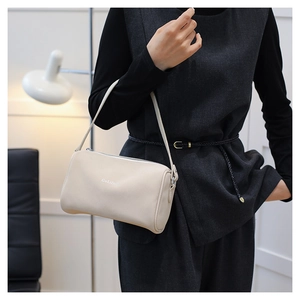 Gros plan d'un sac oreiller minimaliste de couleur crème porté par un mannequin