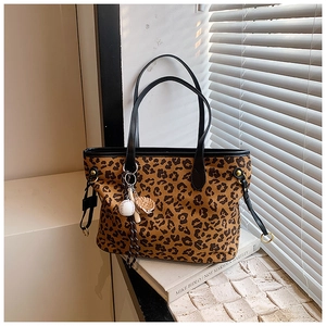 Détail du sac cabas léopard avec ses breloques miniatures de baseball et de gant