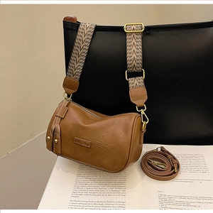 Detail of brown Boston bag with bohemian woven strap and leather tassel zipper