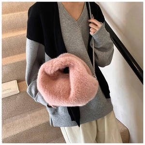 Sac à main rose en fausse fourrure avec chaîne argentée dans un décor intérieur
