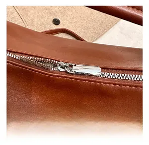 Détail de la fermeture éclair en métal argenté sur un sac bandoulière vintage