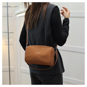 Vue arrière d'un mannequin portant un sac bandoulière cylindre marron avec logo GULIDILI