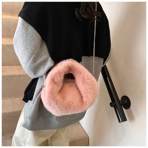 Détail d'un sac bandoulière en fausse fourrure rose avec texture douce et chaîne argent