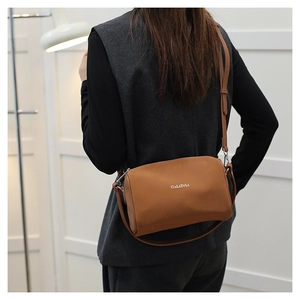 Sac cylindrique marron moderne avec logo blanc sur finition en cuir mat doux de luxe