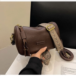 Detail of vintage brown boston bag with stylish wide woven geometric shoulder strap