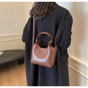 Détail du sac à main en cuir marron avec boucles dorées et lettrage Fashion