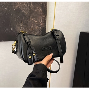 Close-up of litchi texture black leather bag with MUCOOU logo and golden rivets