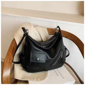 Détail du sac hobo vintage en similicuir noir avec poches zippées et boucles argent