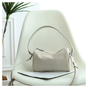 Détail d'un sac oreiller blanc crème avec logo GULUDILI posé sur une chaise minimaliste