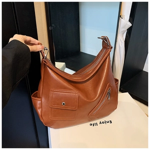 Détail d'un sac hobo rétro en cuir marron avec plusieurs poches extérieures pratiques