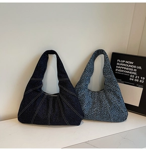 Close-up of leopard print shoulder bags in dark and light denim fabric with zipper detail