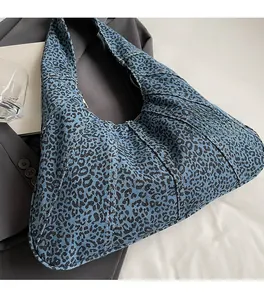 Detail of blue leopard print denim hobo bag with soft fabric and vertical stitching