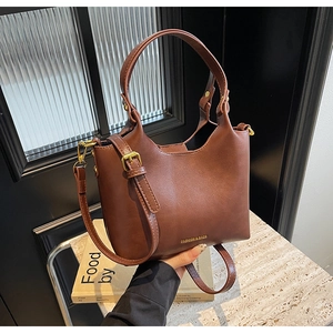 Détail du sac seau marron en similicuir avec boucles dorées et bandoulière amovible