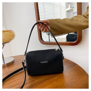 Détail d'un sac polochon noir mat avec fermeture éclair argentée et logo de marque