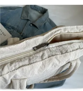 Macro view of smooth metal zipper closure on a quilted cotton tote bag