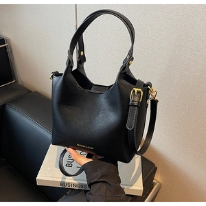 Détail d'un sac seau noir avec ferrures dorées et texture en similicuir PU de qualité
